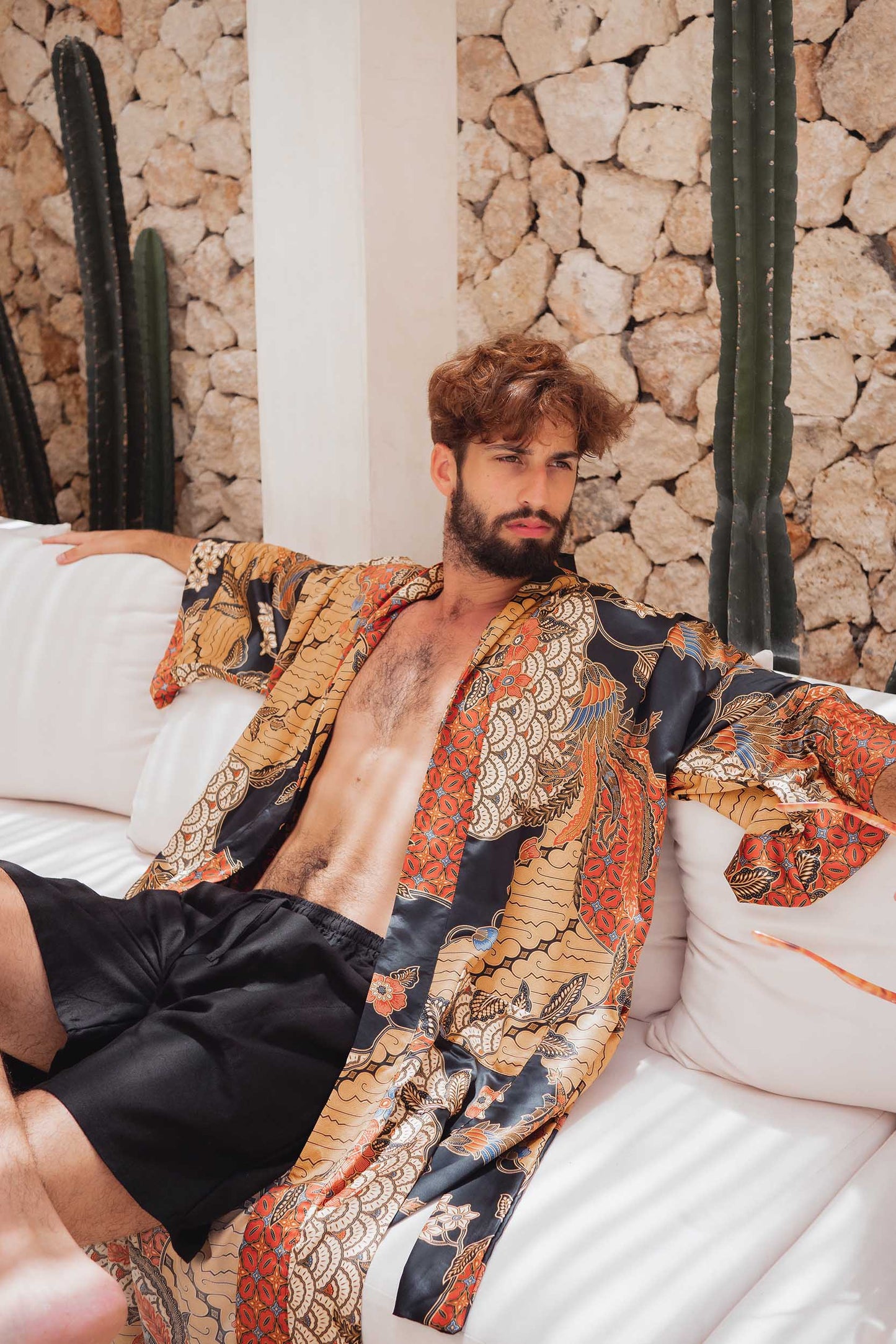 Man sitting in the Agni kimono robe – soft satin long dressing gown handmade in Bali.