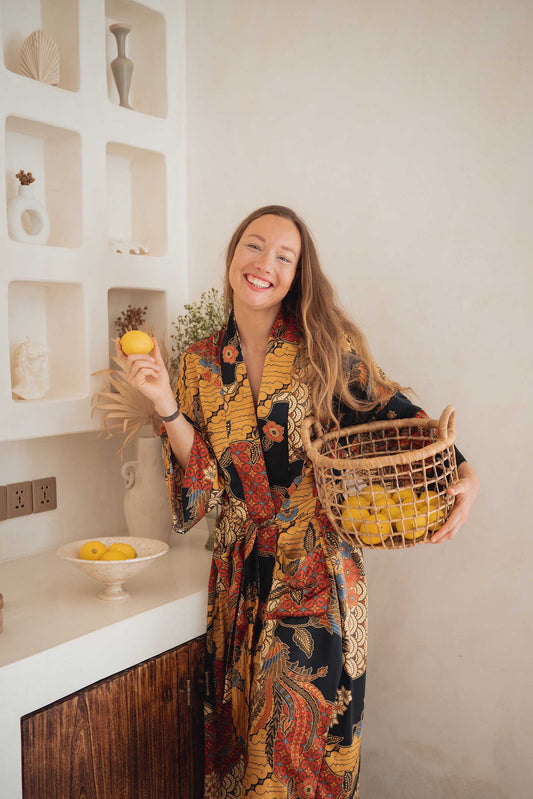 Front view of woman wearing the Agni women’s kimono robe – elegant satin dressing gown with batik-inspired pattern.