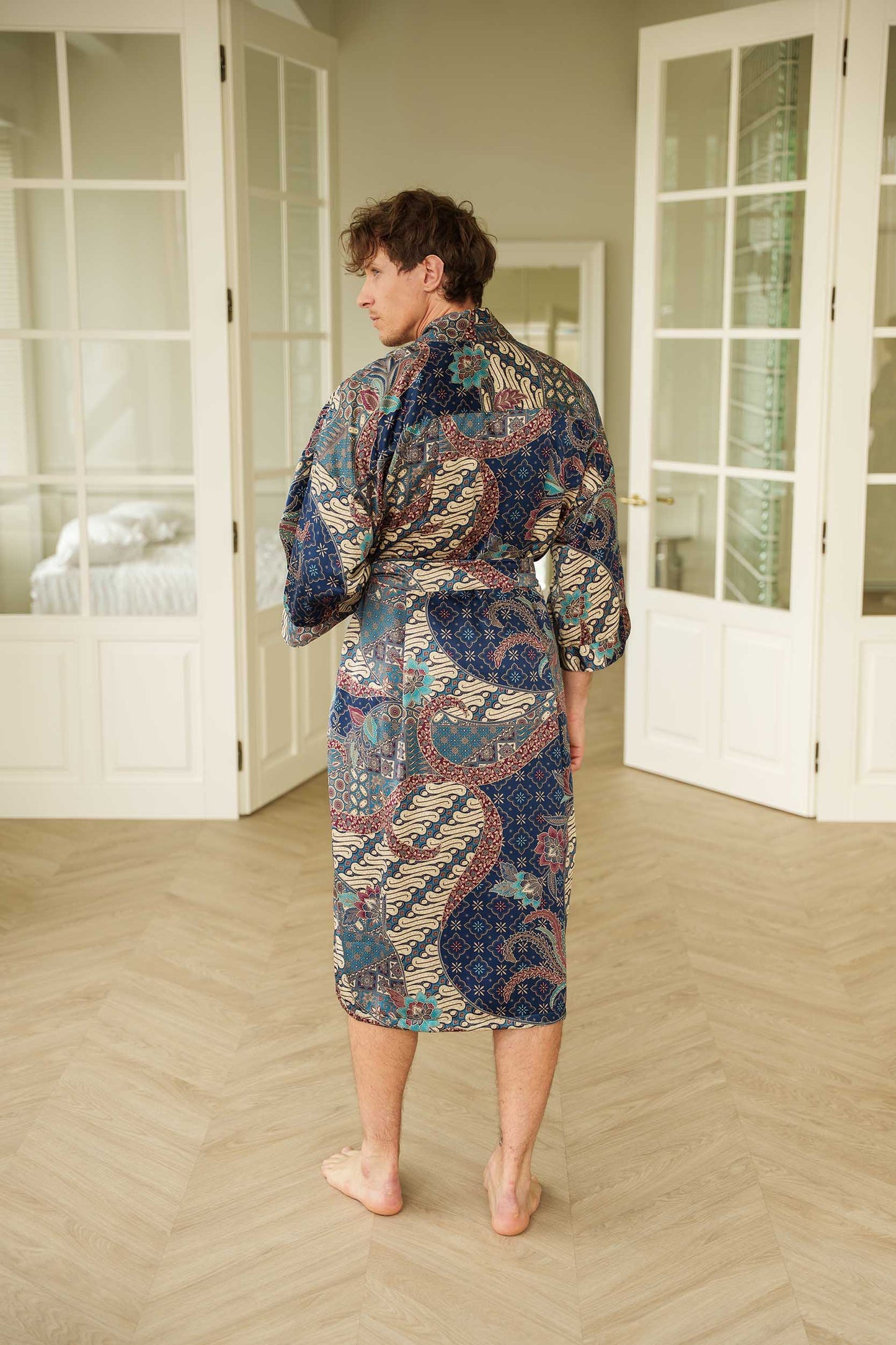 Back view of Angkasa men’s kimono robe – elegant navy satin with turquoise and burgundy batik design.
