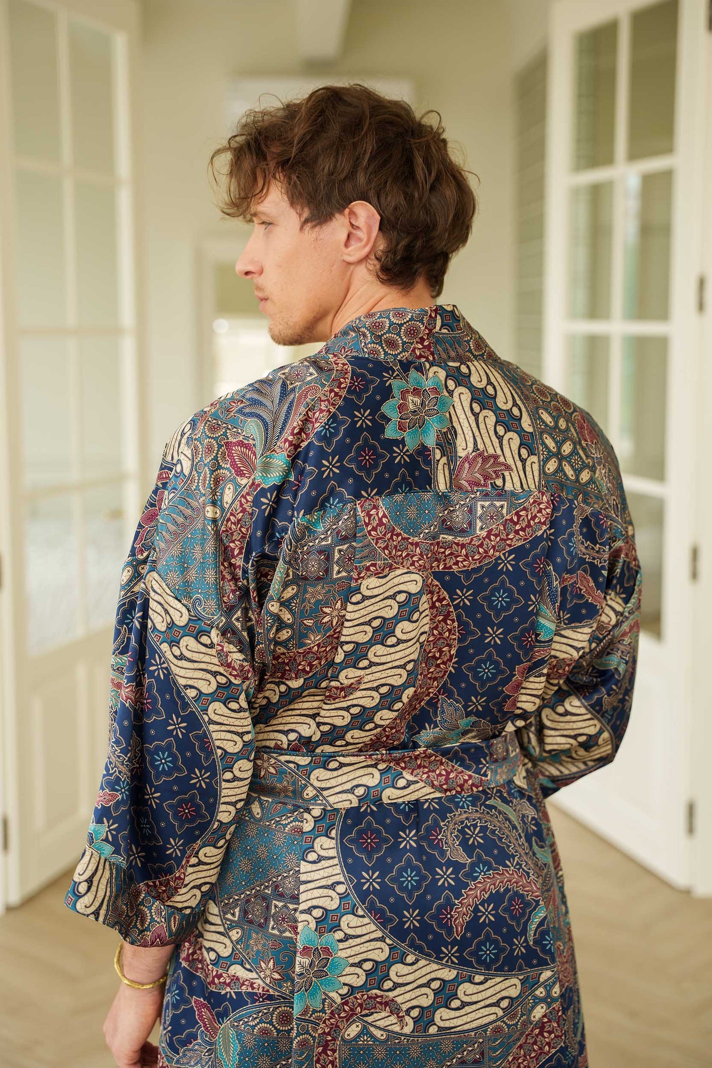 Close-up of Angkasa robe fabric – smooth satin with celestial batik motifs.