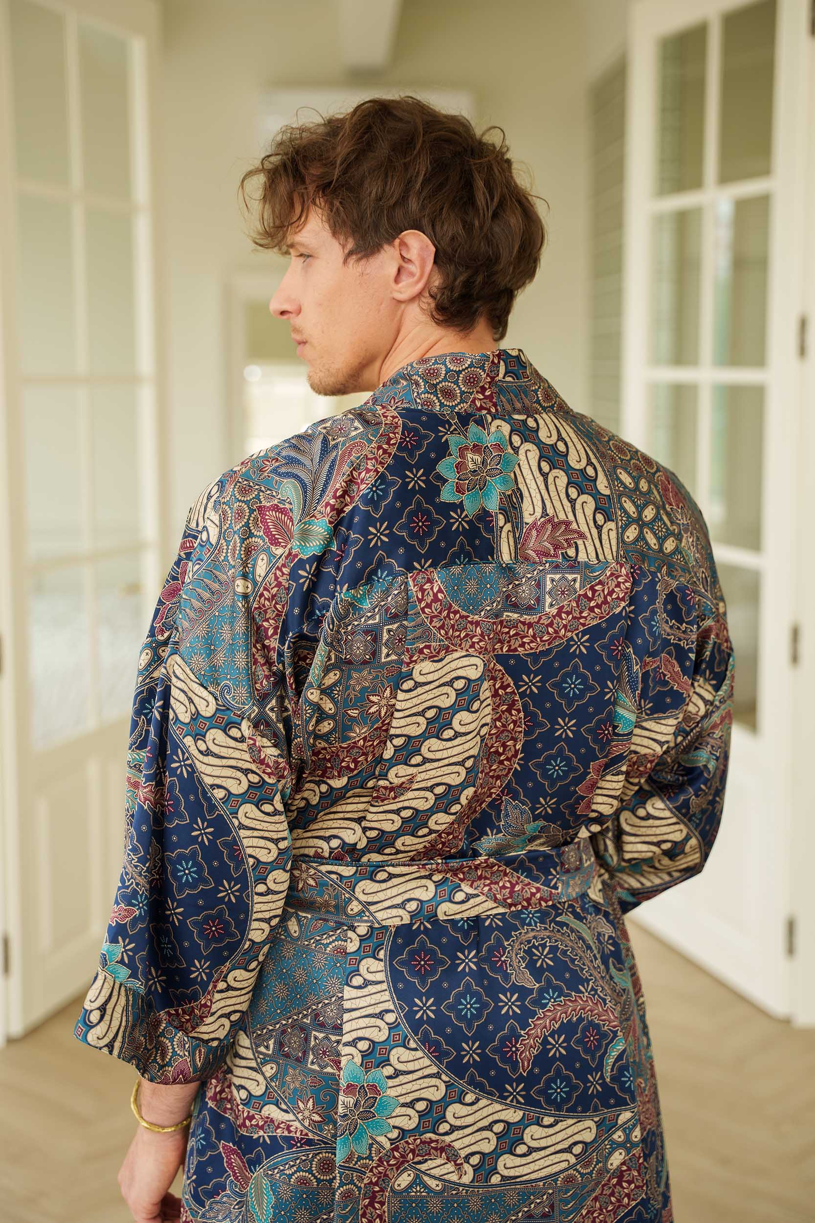 Close-up of Angkasa robe fabric – smooth satin with celestial batik motifs.