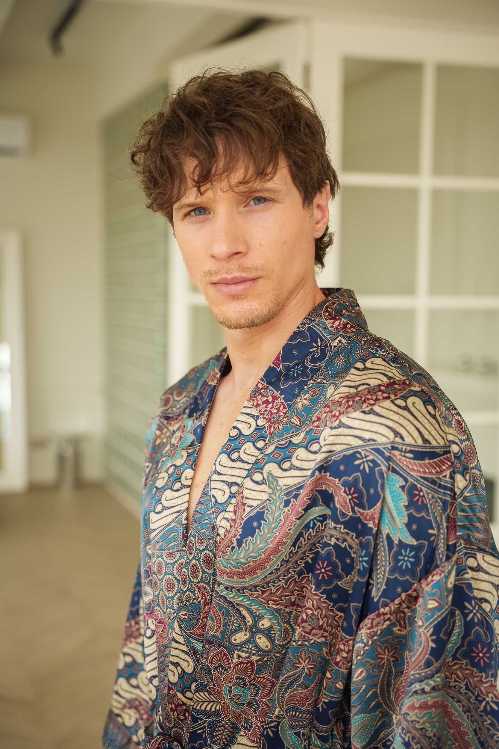 Close-up of Angkasa robe fabric – smooth satin with celestial batik motifs.