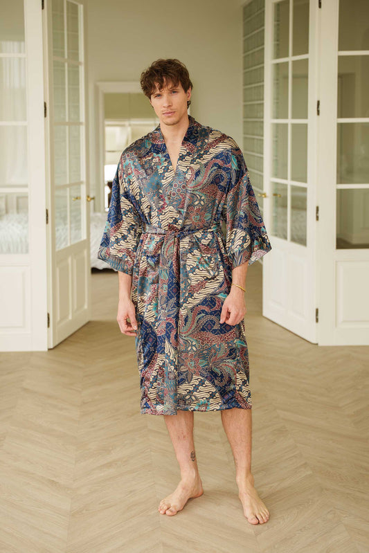 Man wearing Angkasa kimono robe – navy blue long satin dressing gown with celestial batik pattern.