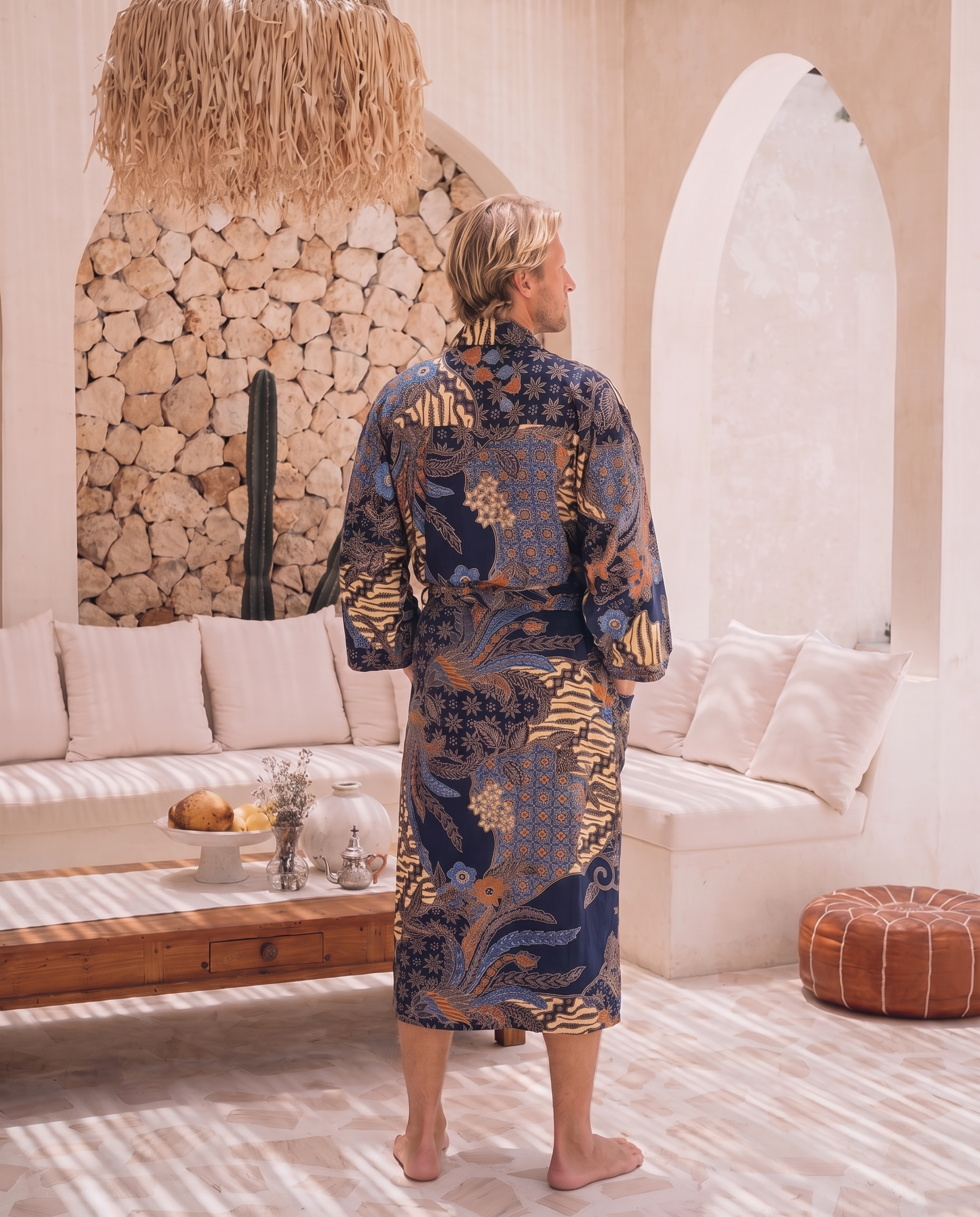 Man wearing navy satin Samudra kimono robe with gold batik print, back view