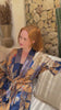 a video of Woman wearing Toré Nilam kimono robe – long blue satin dressing gown with gold batik accents in Bali.