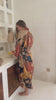 a video of a Woman wearing the Agni women’s kimono robe – long satin dressing gown in orange and gold batik design, handmade in Bali.