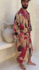 Man wearing Toré Bara kimono robe – long red and beige satin dressing gown with Indonesian batik pattern in Bali