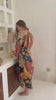 a video of a Woman wearing the Agni women’s kimono robe – long satin dressing gown in orange and gold batik design, handmade in Bali.