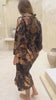 Woman wearing Toré Svarna kimono robe – long black and gold satin dressing gown with batik motifs handmade in Bali