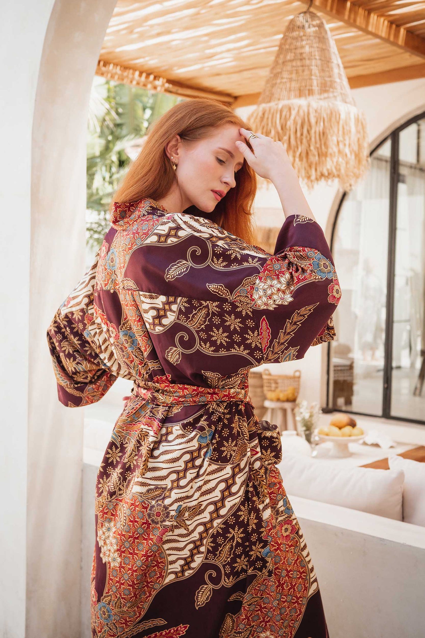 Back view of Toré Ratna robe – elegant women’s kimono in burgundy satin with soft golden pattern.