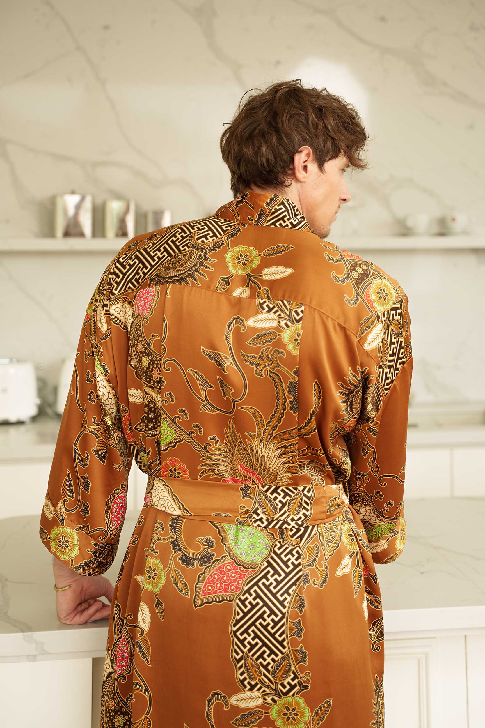 Back view of Surya men’s kimono robe – gold satin with Balinese sun-inspired batik design.