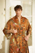 Man wearing Surya golden-orange dressing gown kimono and closing a belt.