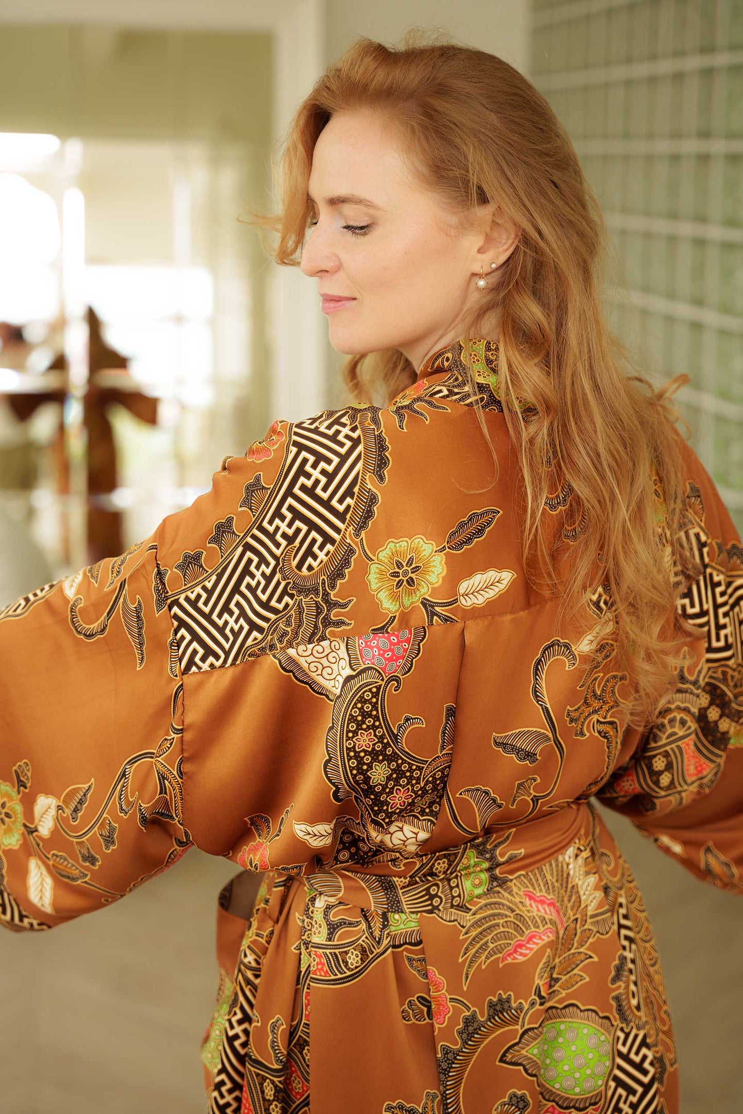 Back view of Surya women’s kimono robe – gold satin with intricate batik design.