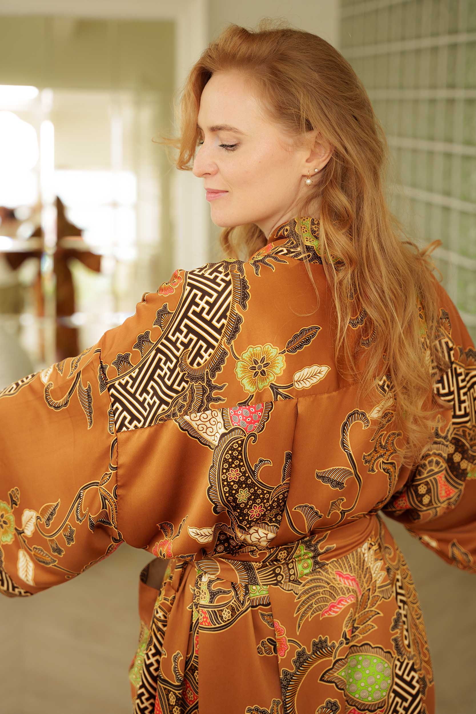 Back view of Surya women’s kimono robe – gold satin with intricate batik design.