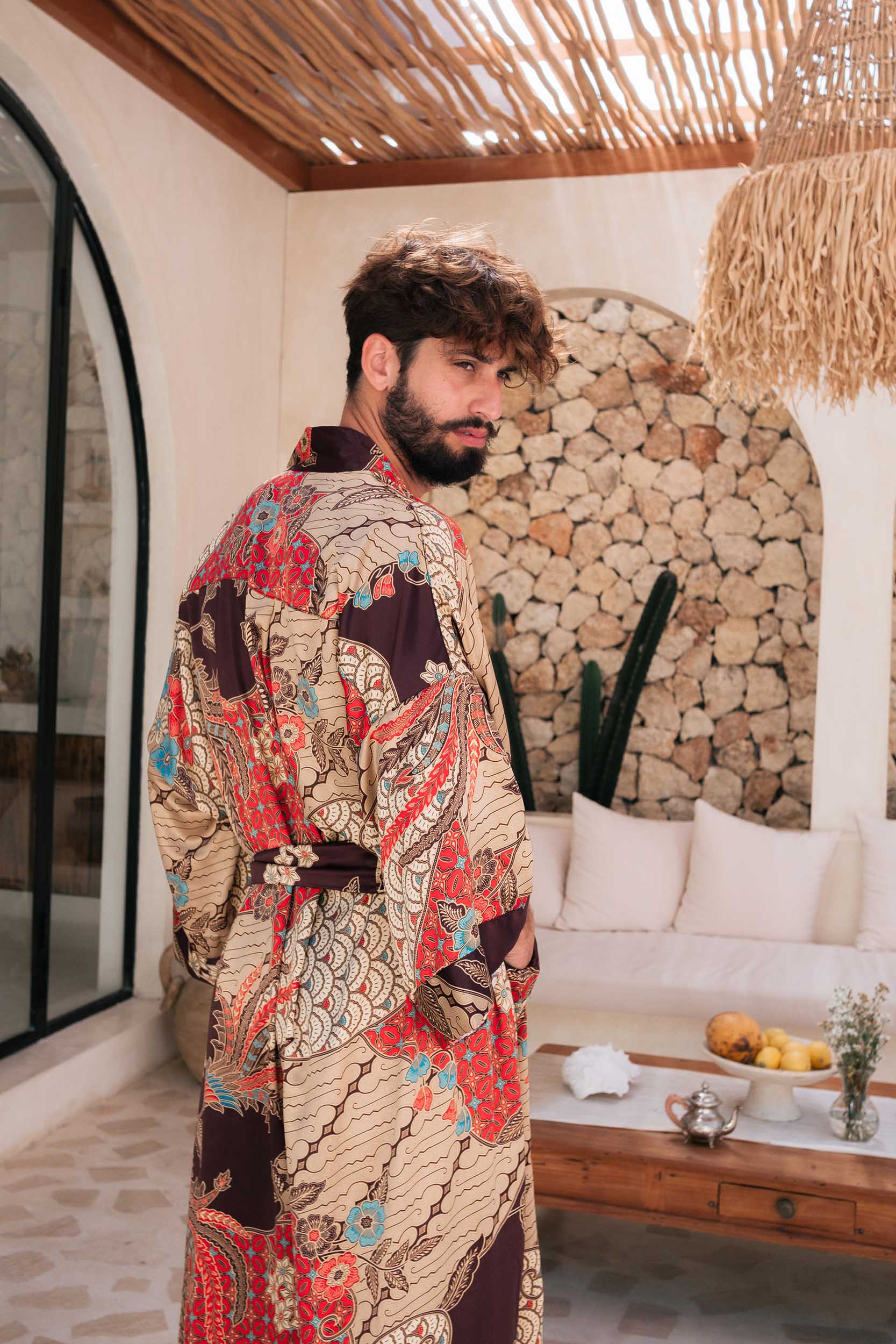 Side view of Toré Bara robe – red satin men’s dressing gown with beige batik details.