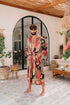 Man wearing Toré Bara kimono robe – long red and beige satin dressing gown with Indonesian batik pattern.