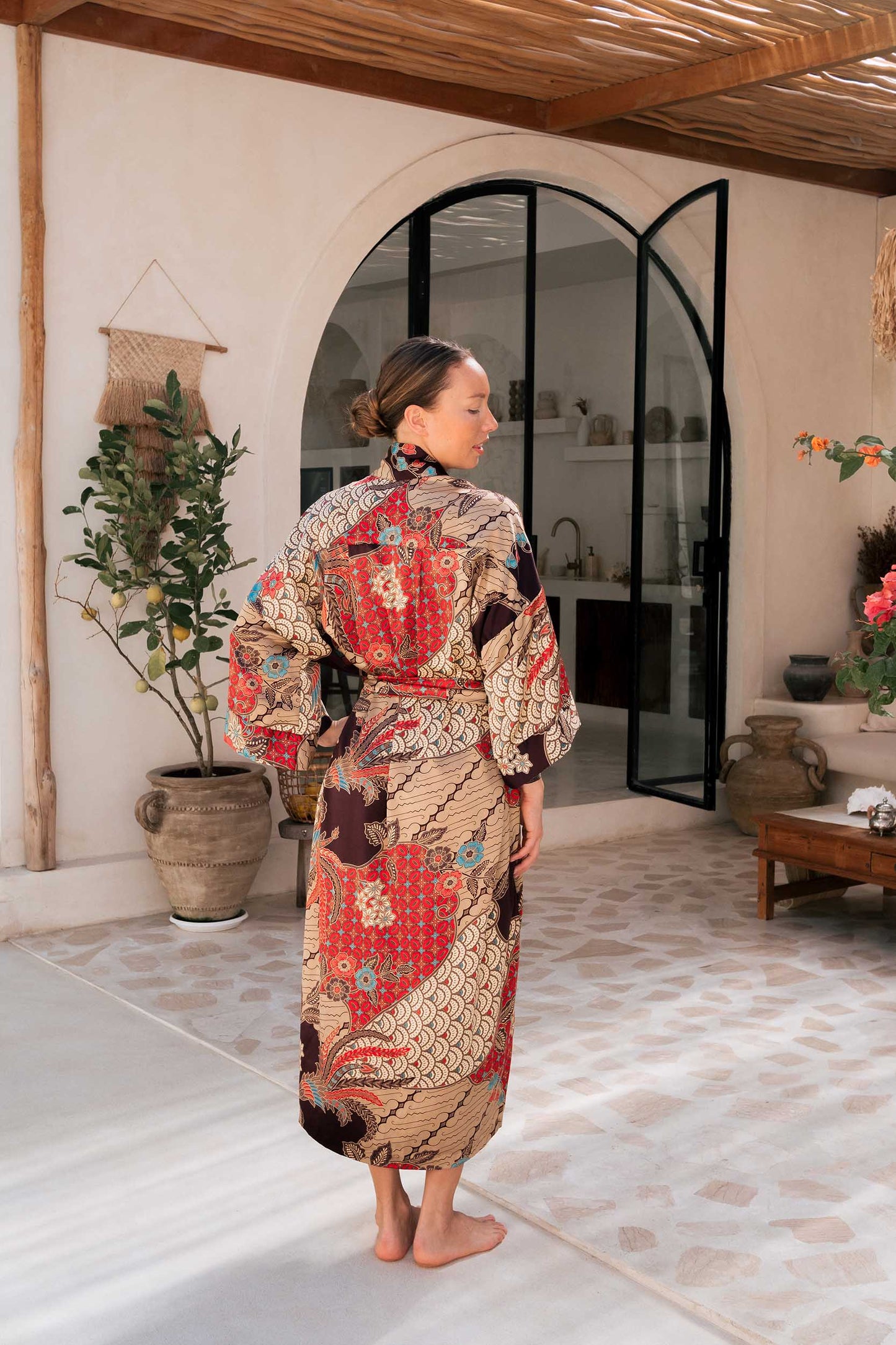Back view of Toré Bara women’s robe – luxury satin kimono with floral and wave batik motifs.