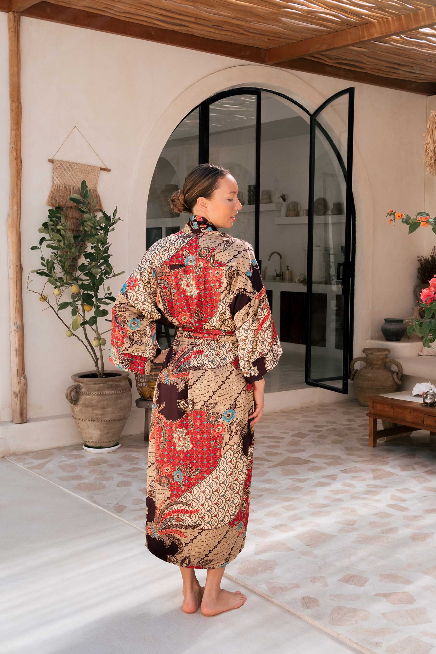 Back view of Toré Bara women’s robe – luxury satin kimono with floral and wave batik motifs.