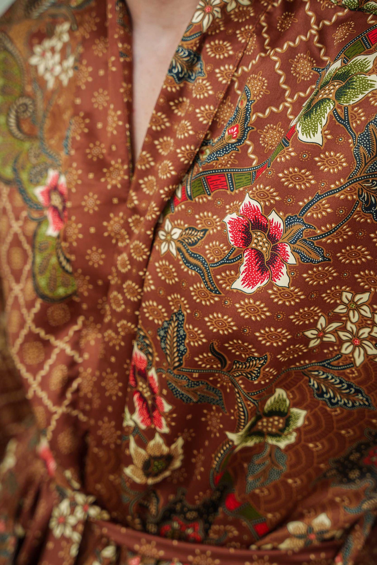Close-up of Toré Bumi robe fabric – smooth satin finish with batik-inspired print.