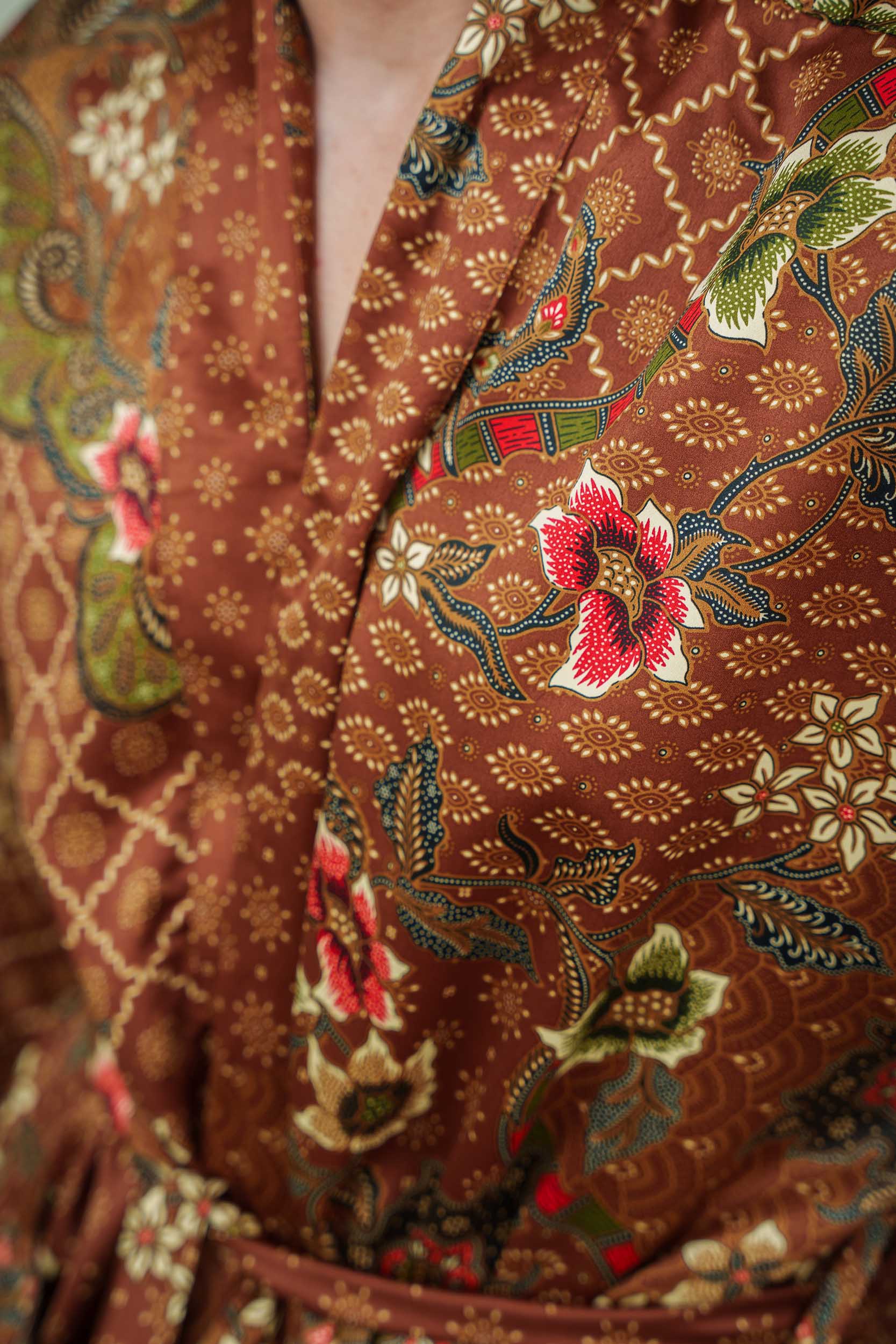 Close-up of Toré Bumi robe fabric – smooth satin finish with batik-inspired print.