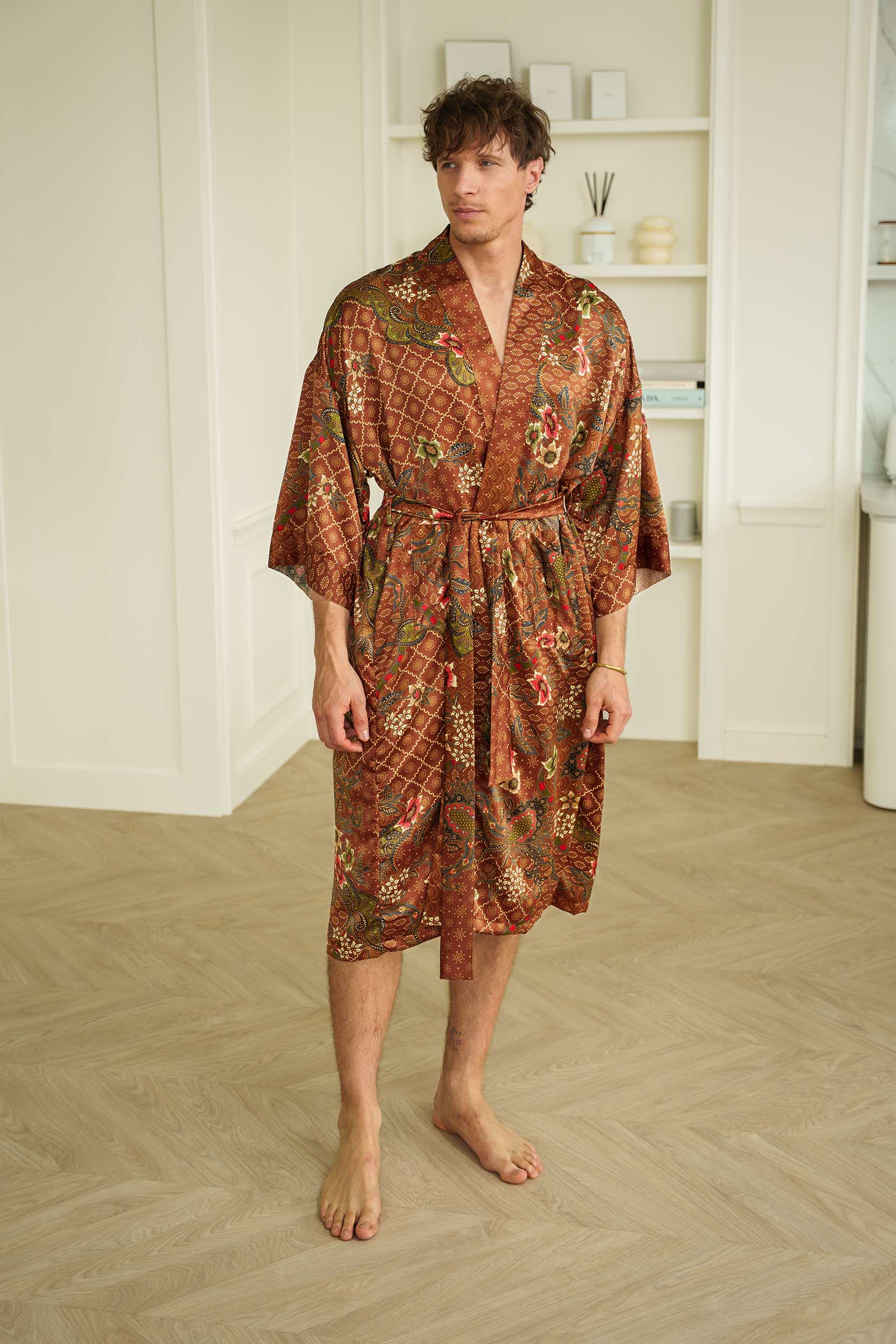 Man wearing Toré Bumi kimono robe – long satin dressing gown in brown and olive batik pattern handmade in Bali.