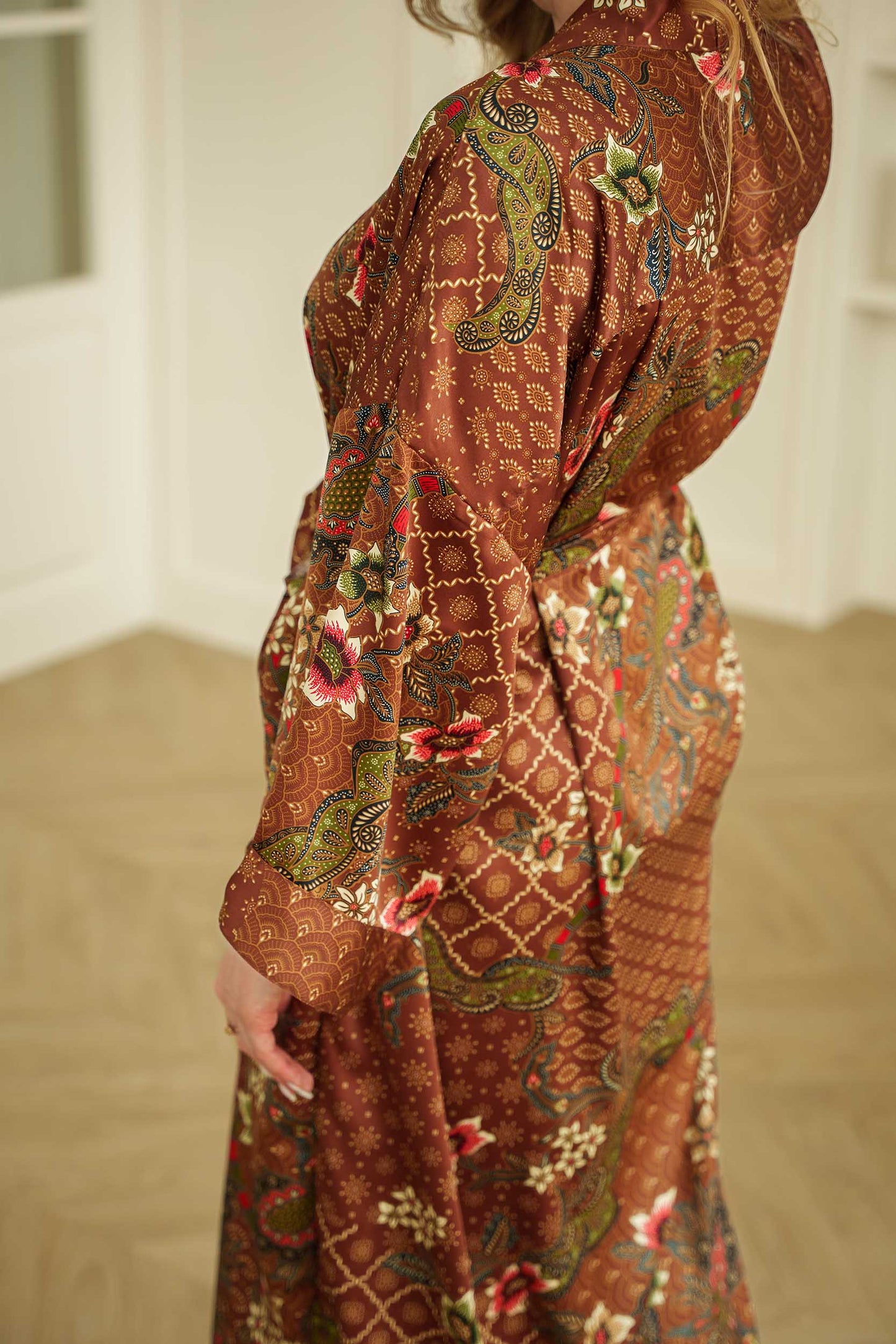 Side view of woman wearing the Toré Bumi satin kimono robe – elegant long dressing gown.