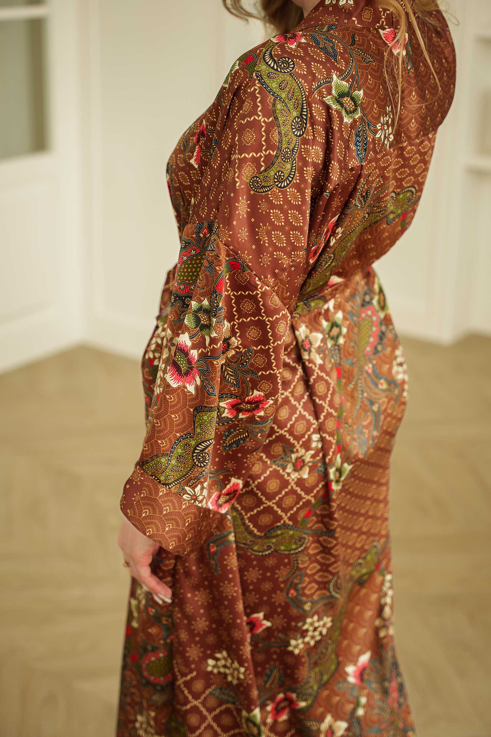 Side view of woman wearing the Toré Bumi satin kimono robe – elegant long dressing gown.