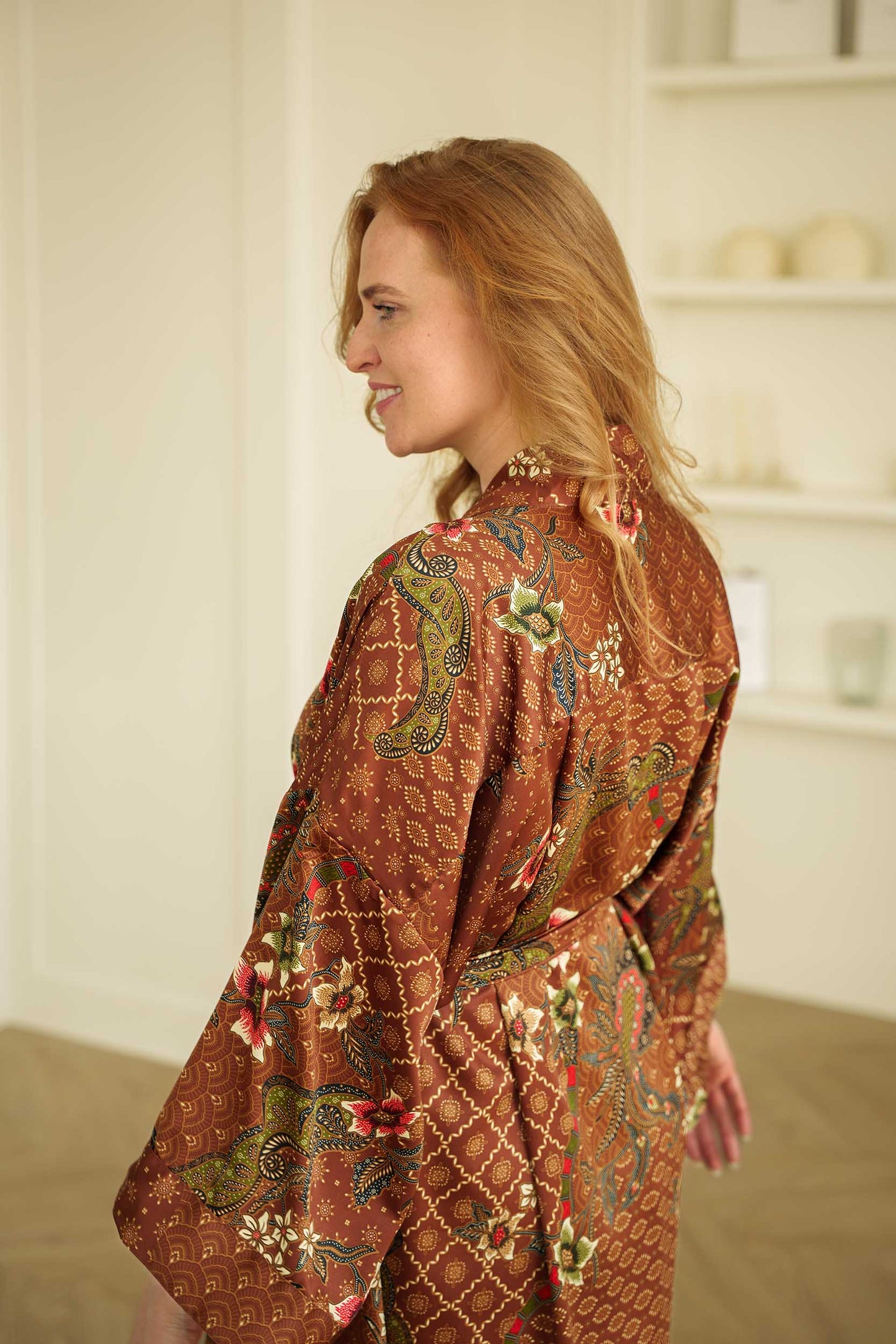 Close-up of Toré Bumi kimono robe fabric – silky satin texture with floral batik print.