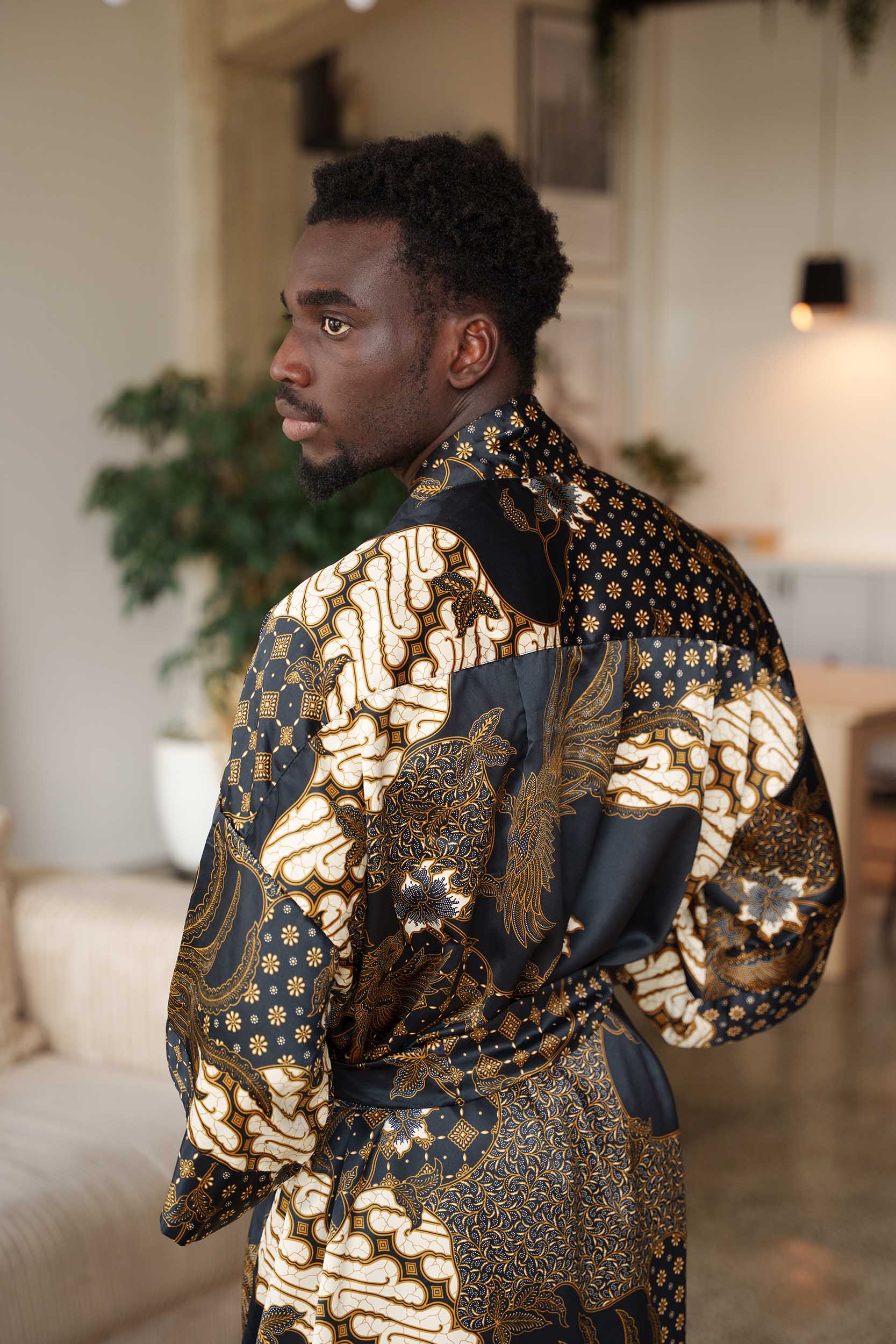 Back view of Toré Kencana robe – men’s black and gold satin kimono with intricate Indonesian motifs.
