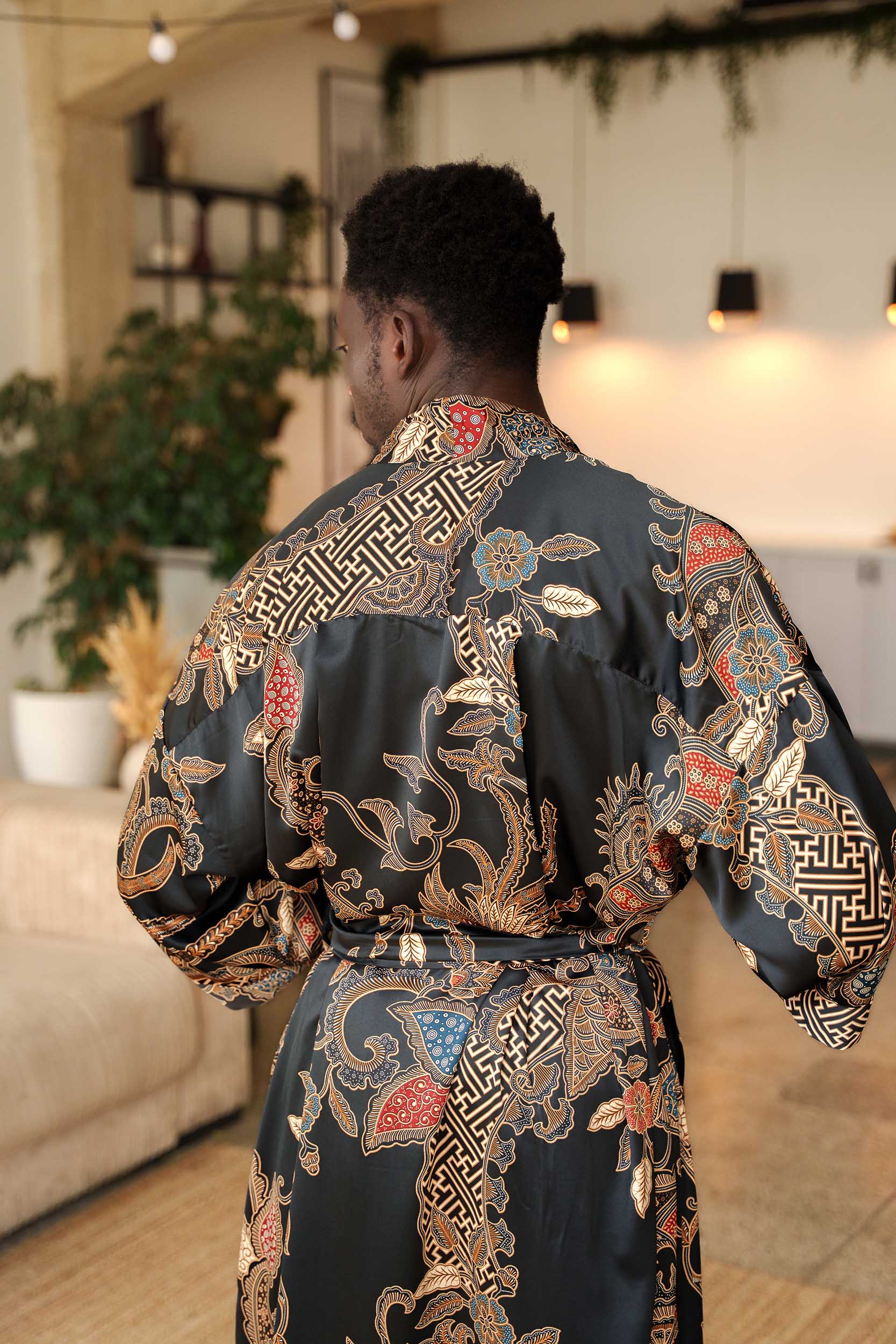 Back view of Toré Malam robe – men’s black satin kimono with elegant gold batik motifs.