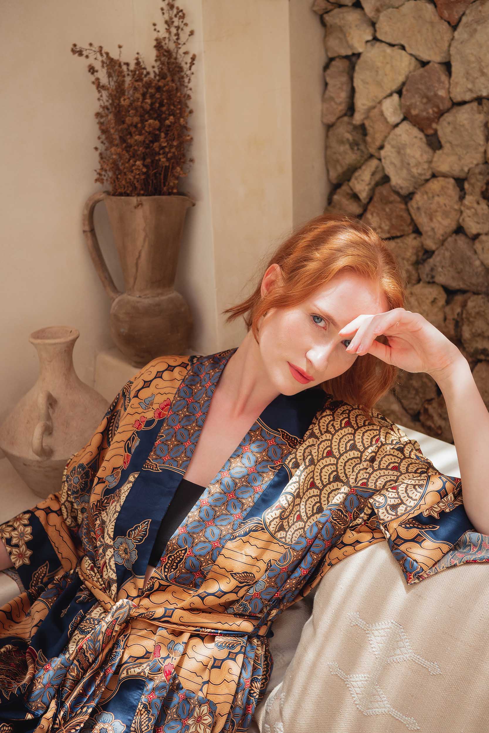 Close-up of Toré Nilam fabric – smooth satin with gold and indigo batik details.