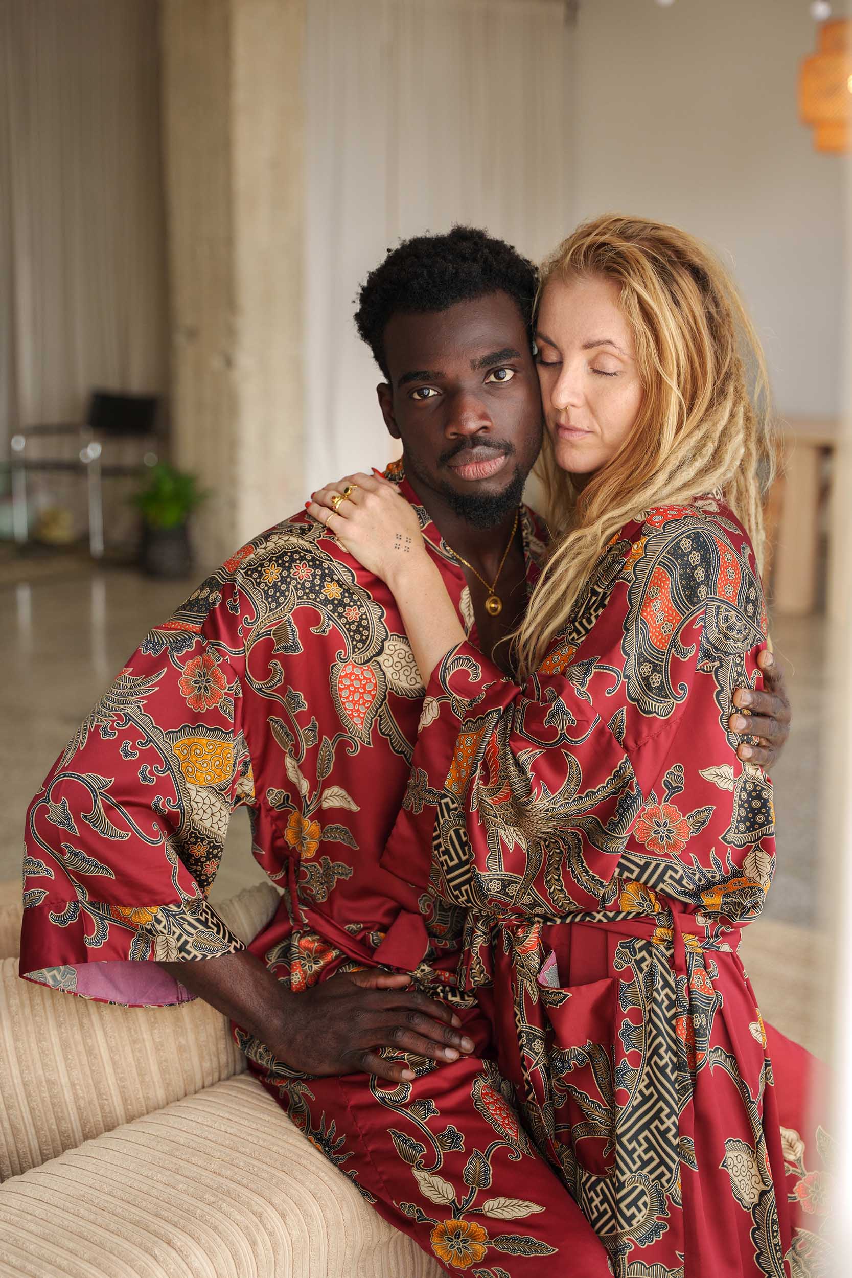 Man and woman in Toré Sekar robes – luxury couple kimono robes in cherry-red satin, perfect for anniversaries or weddings.