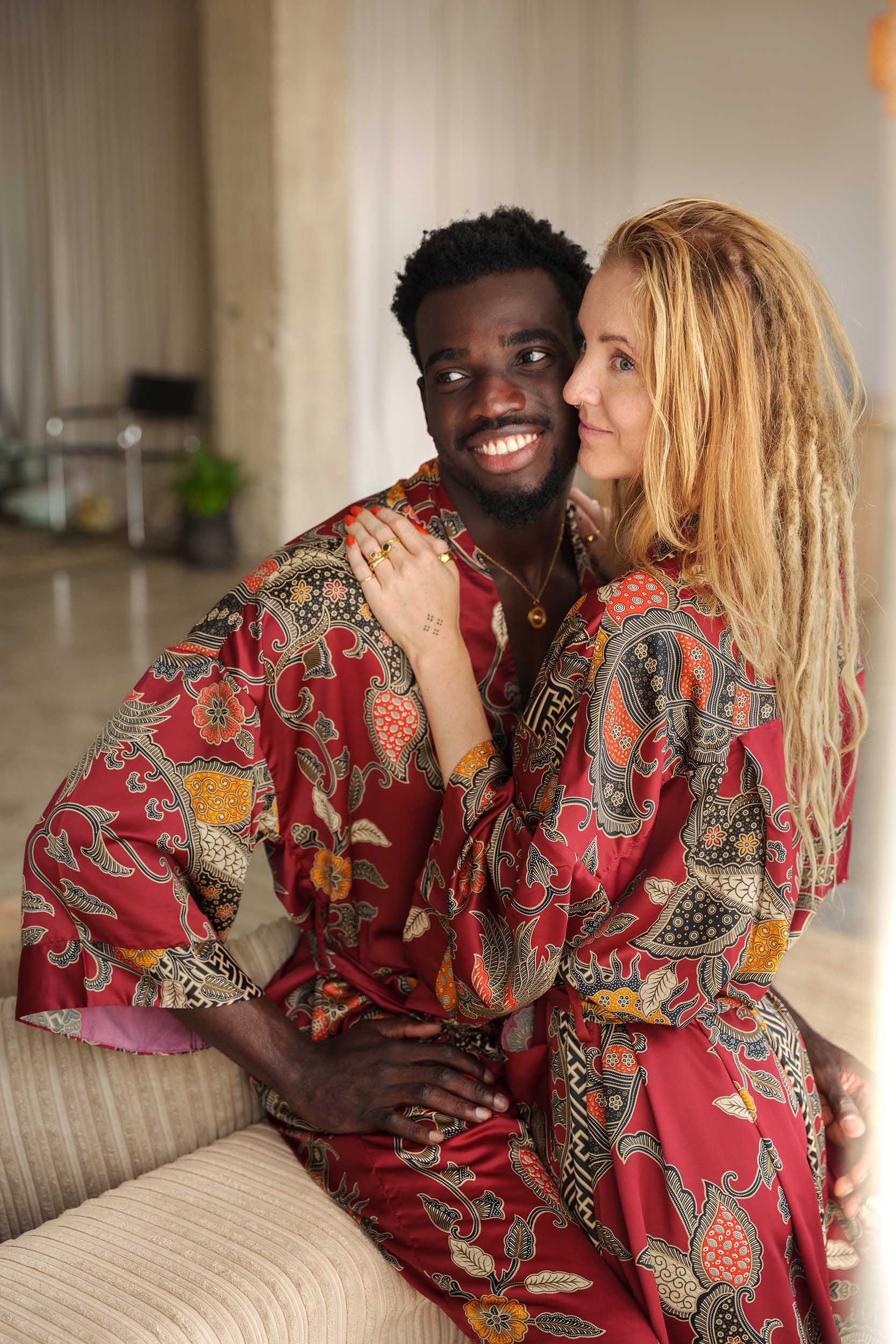 Man and woman in Toré Sekar robes – luxury couple kimono robes in deep red satin, perfect for birthdays or anniversaries.