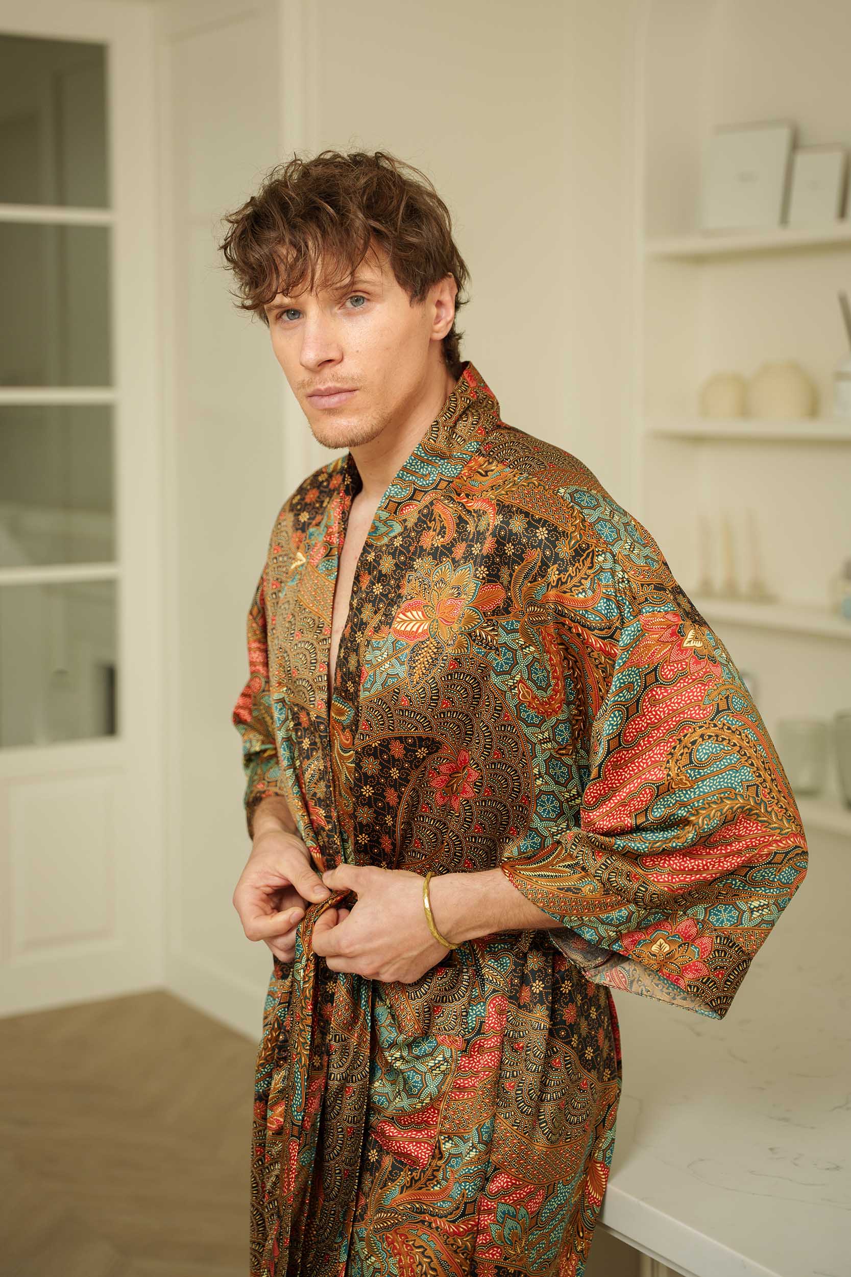 Close-up of Toré Semesta robe fabric – smooth satin texture with intricate batik details.