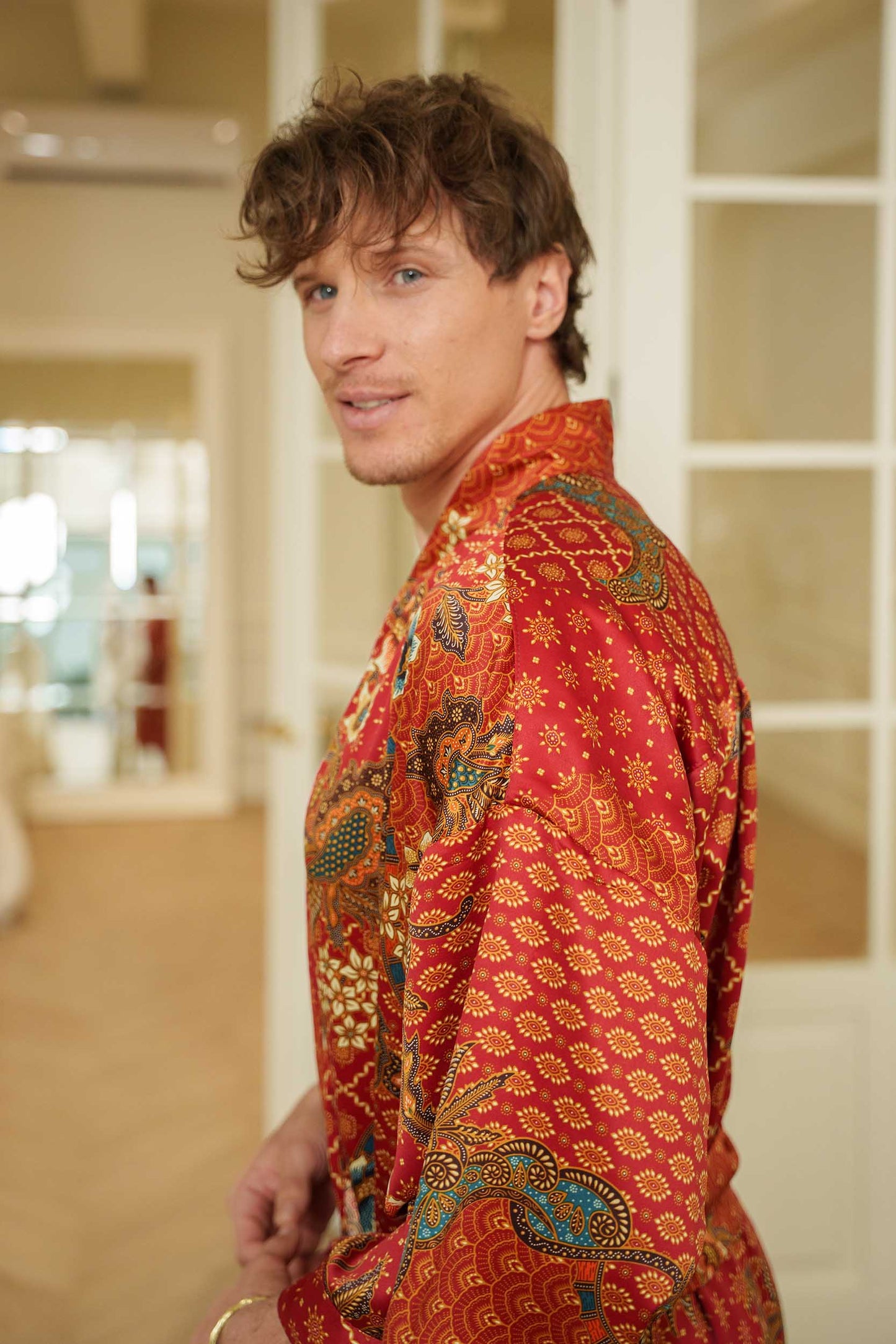 Side view of Toré Senja men’s kimono robe – long red satin robe with relaxed fit and waist belt.